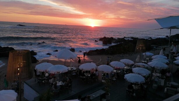A beachside restaurant with outdoor seating and a view of the sunset over the ocean. - Studio with courtyard, at 3 min walking from the beach and 20 from center by BUS (Porto)