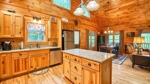 Ein Holzblockhaus mit Küche, Essbereich und Wohnzimmer.