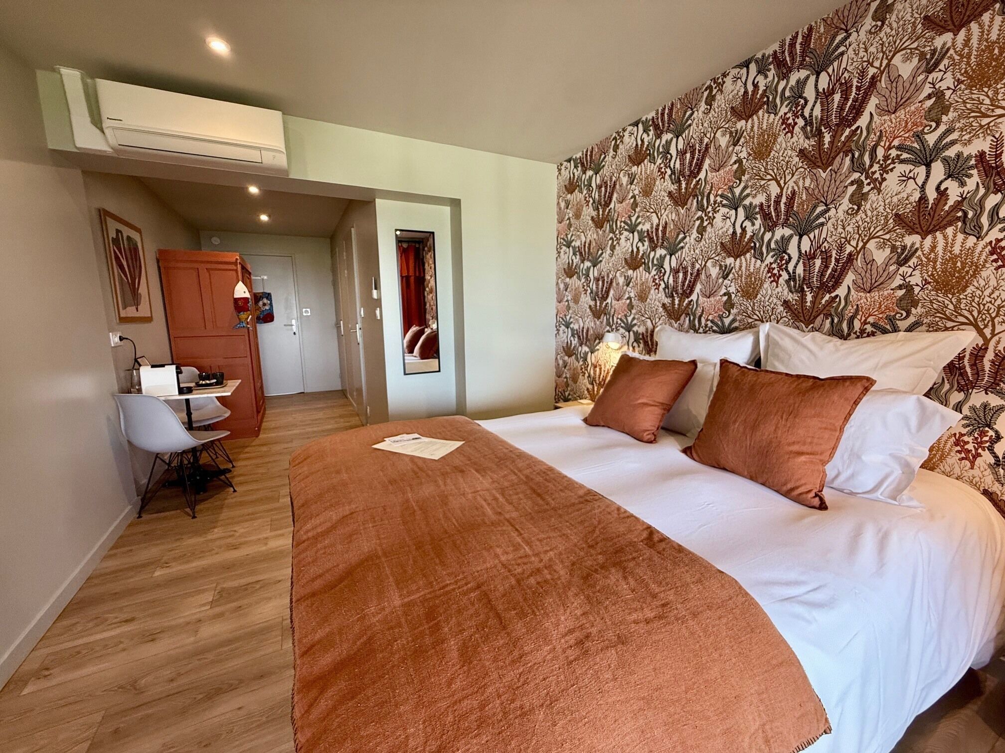 Une chambre d’hôtel avec un lit, un bureau et une chaise.