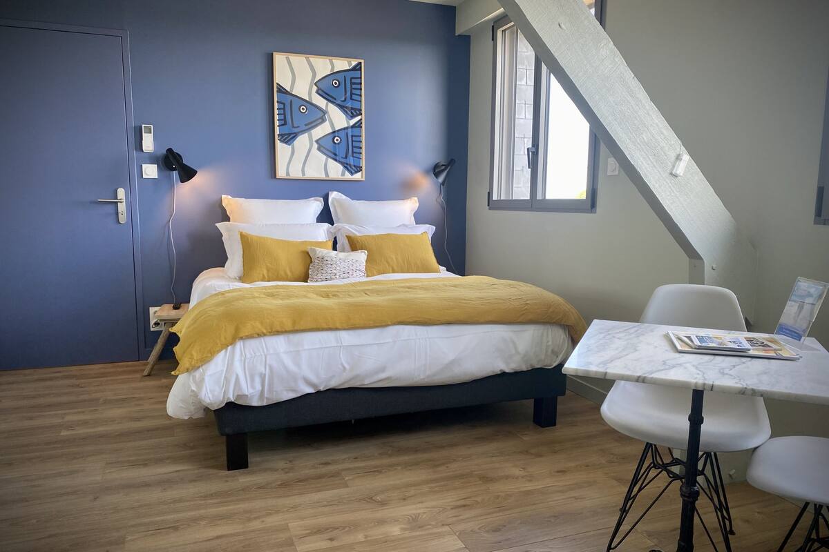 A bedroom with a bed, bedside table, and a chair.