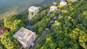 An aerial view of a coastal property with multiple buildings, a parking area, and lush greenery. - Point Pleasant - Perfect Romantic Getaway - 3 Pools/Intimate Beach (St Thomas)