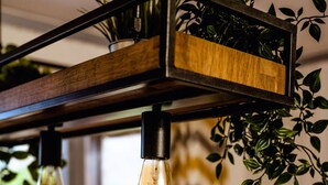 A dining area with a wooden ceiling, hanging light bulbs, and a table set for a meal. - Luxurious Mountain Retreat Lodge Hunters Quay (Dunoon)
