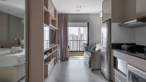 Une chambre d’hôtel moderne comprenant un lit, un canapé, un coin cuisine et une vue sur la ville.