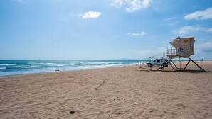 Une plage avec une tour de surveillance et un véhicule blanc.