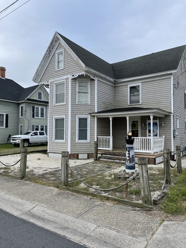 A two-story house with a porch and a front yard.