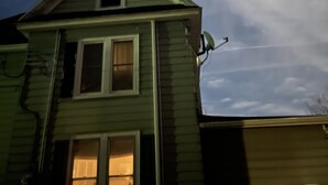 Una casa con techo inclinado, antena parabólica y ventana visible.
