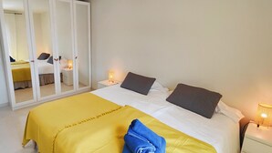 A bedroom with a bed, a wardrobe, and two bedside lamps. - AP379 - Casa Seger - Parador (Nerja)