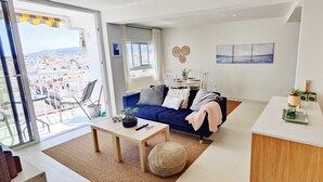 A modern living room with a sofa, coffee table, and a view of the city. - AP379 - Casa Seger - Parador (Nerja)