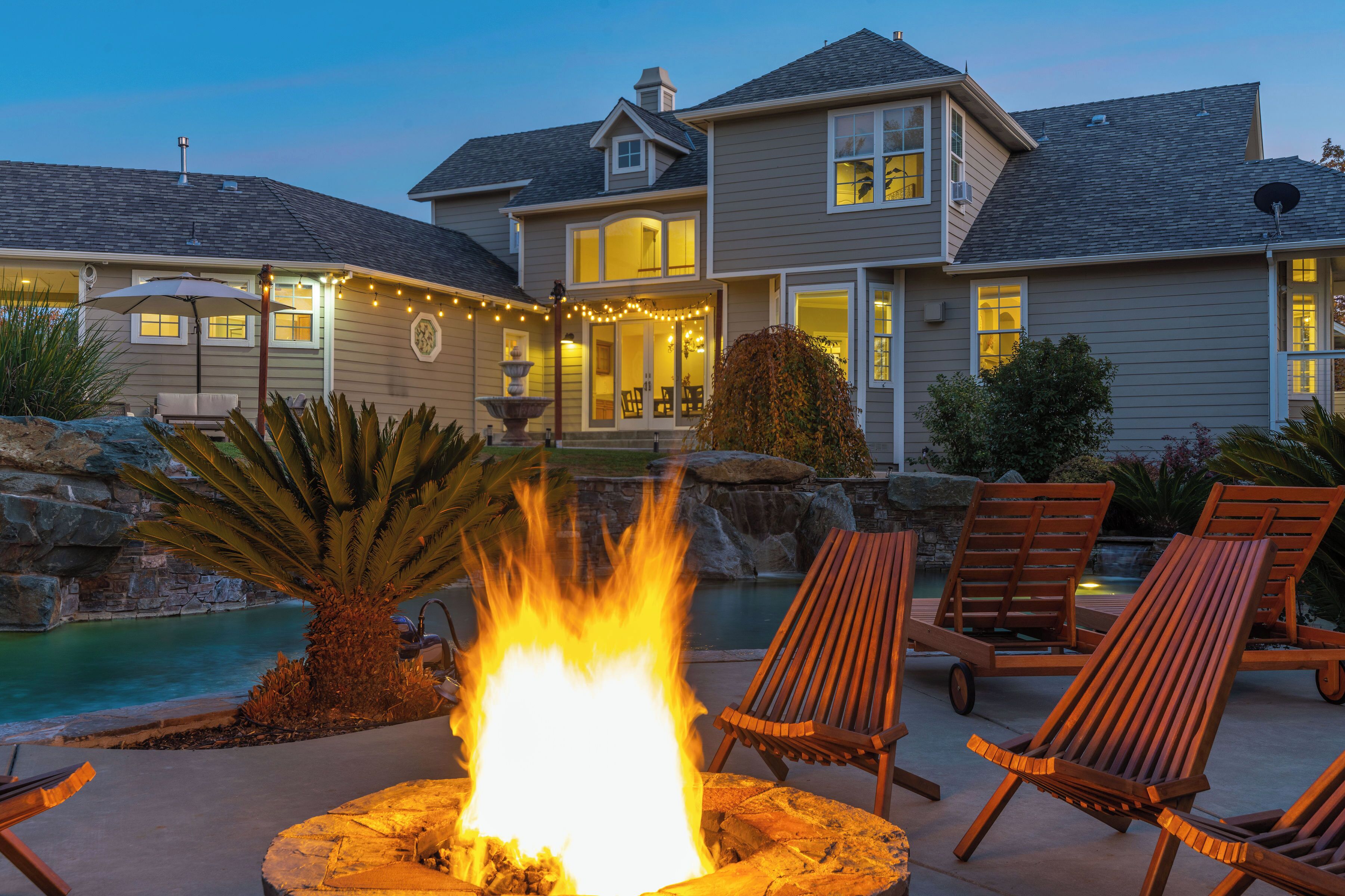 A house with a fire pit, outdoor seating, and a swimming pool.