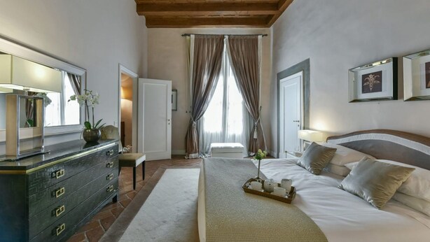 A bedroom with a bed, dresser, and a mirror. - Boccaccio elegant apartment in Oltrarno (Firenze)