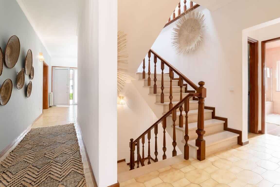 A staircase with wooden balusters and a textured wall decoration.