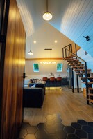 Un interior moderno con escalera de madera, comedor y cocina.