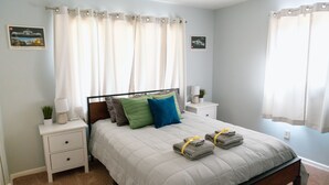 A neatly arranged bedroom with a bed, bedside tables, and curtains. - Builditplace! Kid friendly Stay, Play and Create! (Akron)