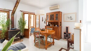 Un salon chaleureux avec un poêle en bois, une table à manger, des chaises et une bibliothèque.