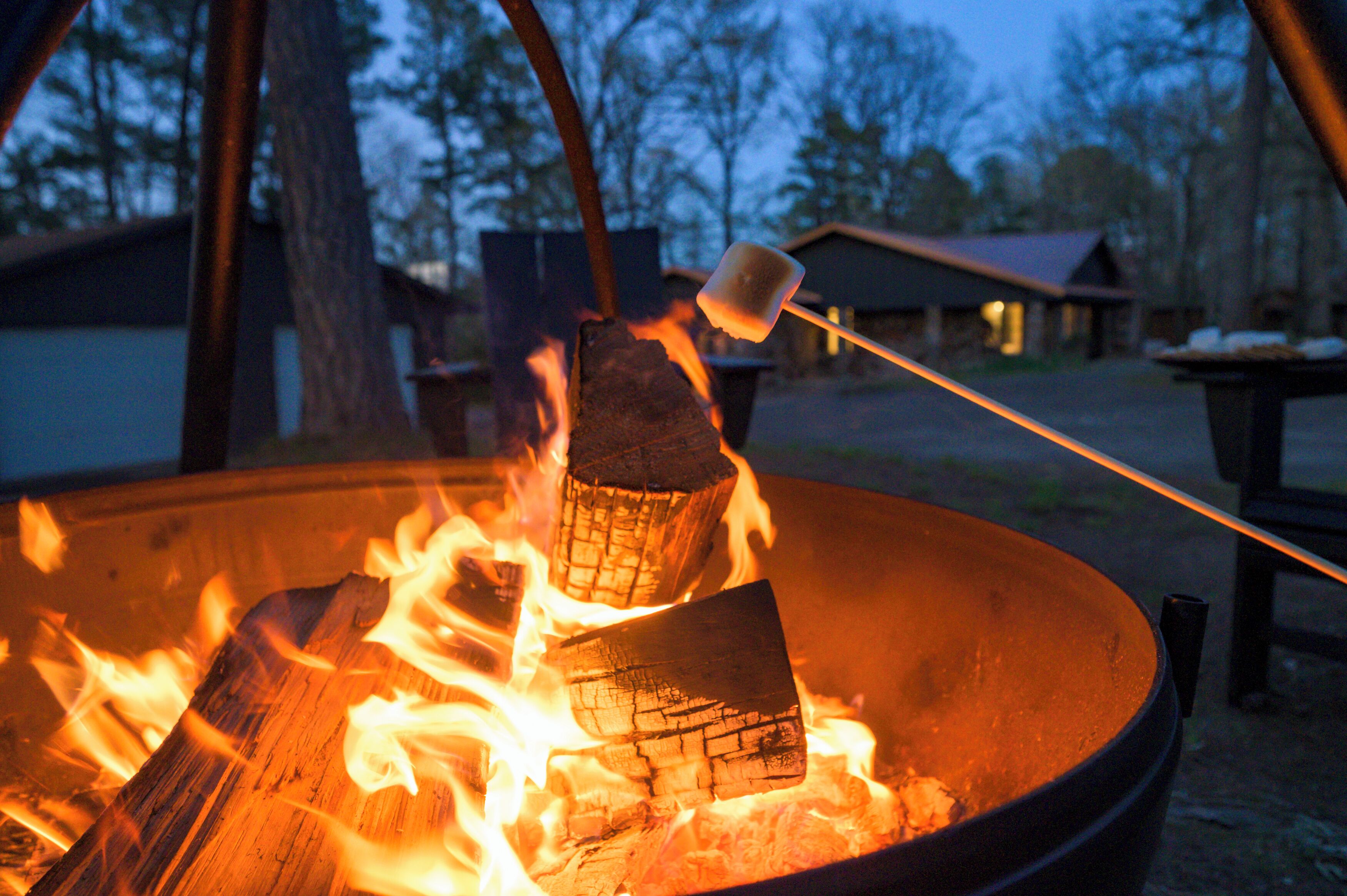 A campfire with a marshmallow being roasted.