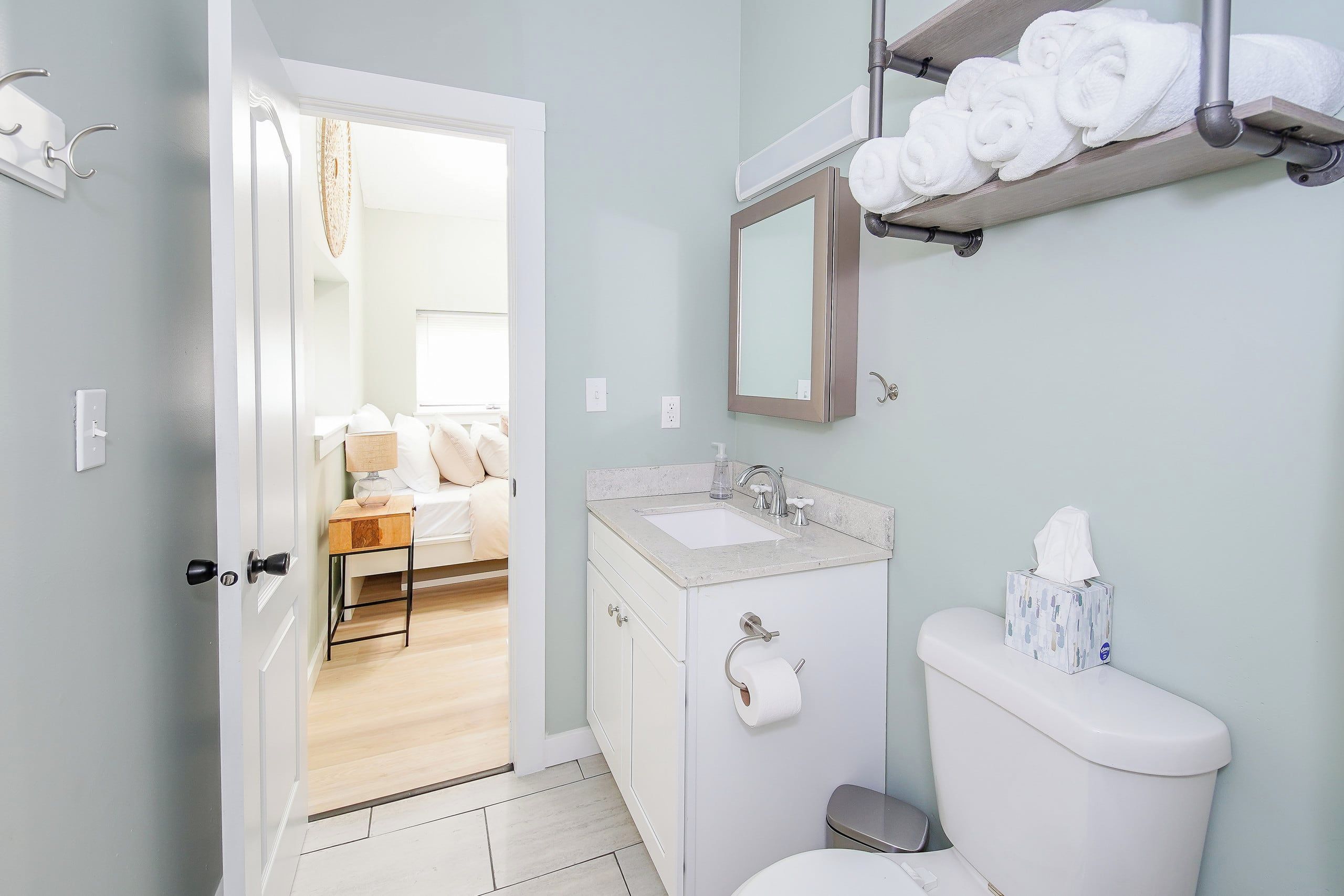 A bathroom with a toilet, sink, and towel rack.