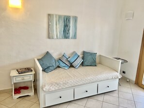 Relax in a serene bedroom with a comfortable bed, nightstand, and abstract art.