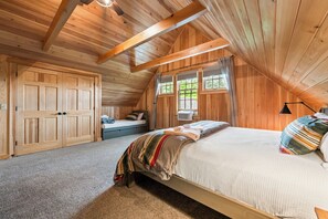Une chambre confortable avec un grand lit, une armoire et une fenêtre avec des rideaux.