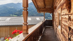 A wooden balcony with a view of mountains and a metal roof. - Neuhaus Alm Holiday Home with Mountain Views, Open Terrace and Wi-Fi (Gerlosberg)