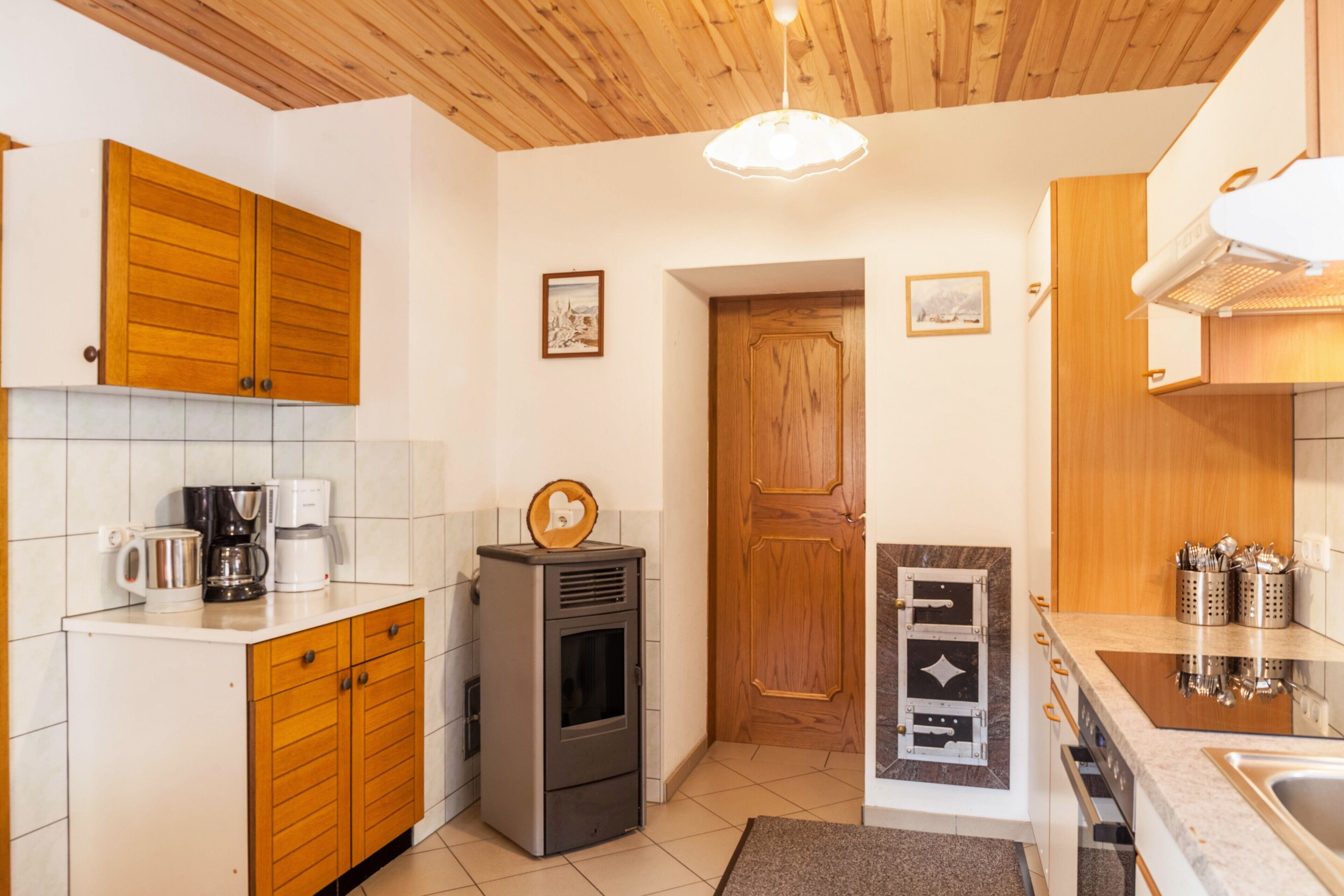 A kitchen with wooden cabinets, a built-in stove, a coffee maker, and a microwave.