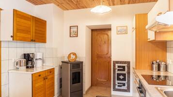 A kitchen with wooden cabinets, a built-in stove, a coffee maker, and a microwave.