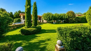 A well-maintained garden with neatly trimmed hedges, a stone fountain, and a building with a tiled roof. - Timeless l'Antico Mulino Della Bozza in Brebbia, Brebbia, Italy (Brebbia)