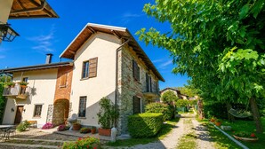A traditional stone building with a balcony, surrounded by a well-maintained garden and a gravel path. - Timeless l'Antico Mulino Della Bozza in Brebbia, Brebbia, Italy (Brebbia)