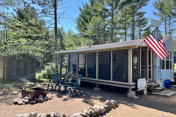 Front of Park Model w fire pit and screened in deck entrance