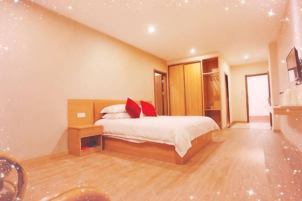 A bedroom with a bed, nightstands, a wardrobe, and a mirror.