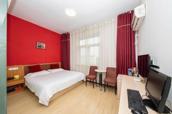A hotel room with a bed, two chairs, a desk with a computer, and an air conditioning unit. - City 118 Express Hotel (Yangzhou Dongguan Street Heyuan Branch) (Yangzhou)