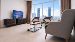 A modern living room with a large window, a flat-screen TV, a coffee table, and two chairs. - Vortex Suites KLCC by Luna (Kuala Lumpur)