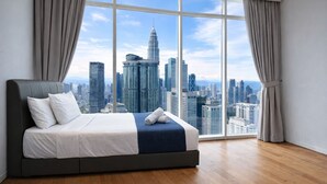 A bedroom with a large window, a bed, and a cityscape view. - Vortex Suites KLCC by Luna (Kuala Lumpur)