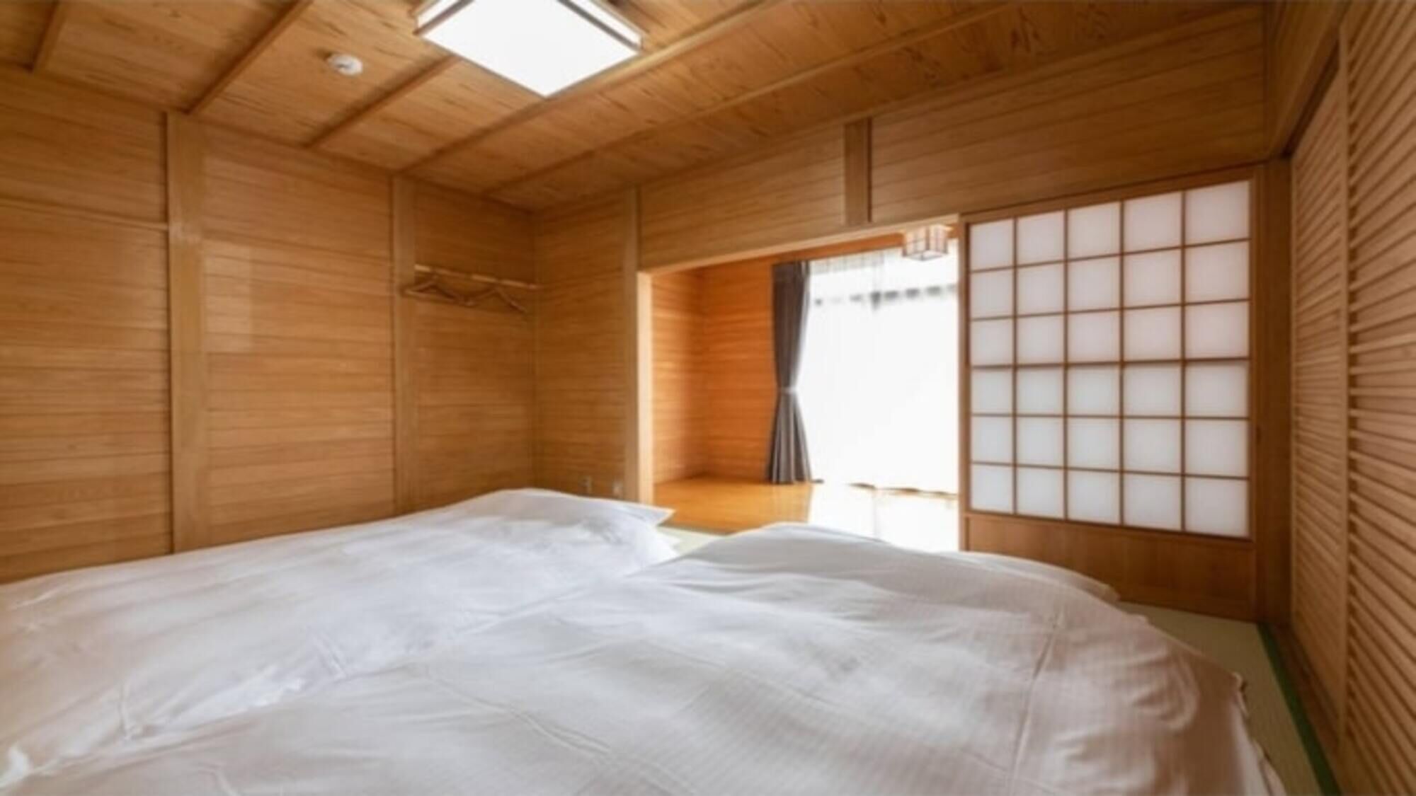 A room with wooden walls and a bed with white bedding.