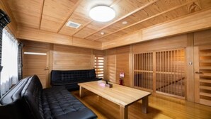 A wooden interior with a sofa, a table, and sliding doors. - YUFUIN O-YADO YUKI ONSEN (Yufu)