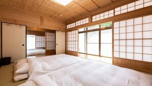 A traditional Japanese-style room with tatami flooring, a large shoji screen window, and a futon bed. - YUFUIN O-YADO YUKI ONSEN (Yufu)
