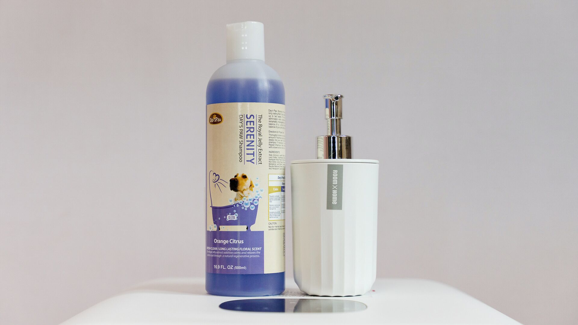 Una botella de champú Day's Paw Serenity y un cepillo de dientes eléctrico blanco.