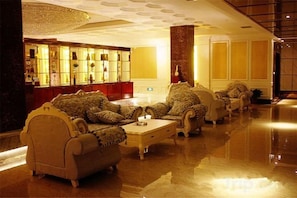 A lobby with a bar area, seating arrangement, and a polished floor. - Haiwang Hongya Hot Spring Hotel (Wen County)