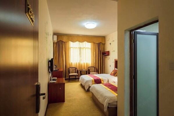 A hotel room with two beds, a desk, a chair, and a window with curtains. - Haiwang Hongya Hot Spring Hotel (Wen County)