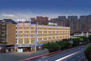 A multi-story hotel with a central courtyard, surrounded by other buildings.