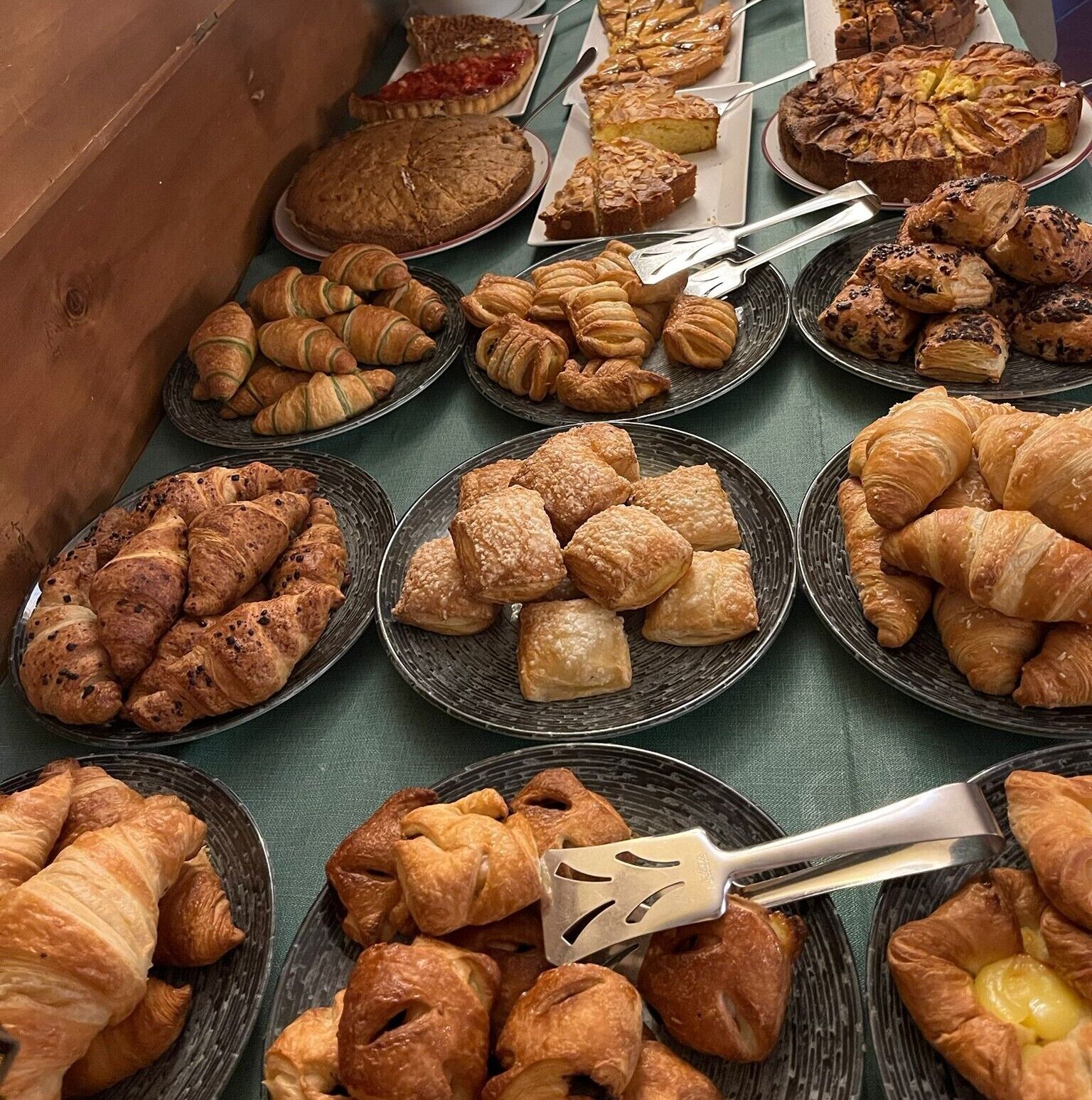 Une variété de produits de boulangerie, notamment des tartes, des tourtes et des pâtisseries, présentés sur des assiettes.
