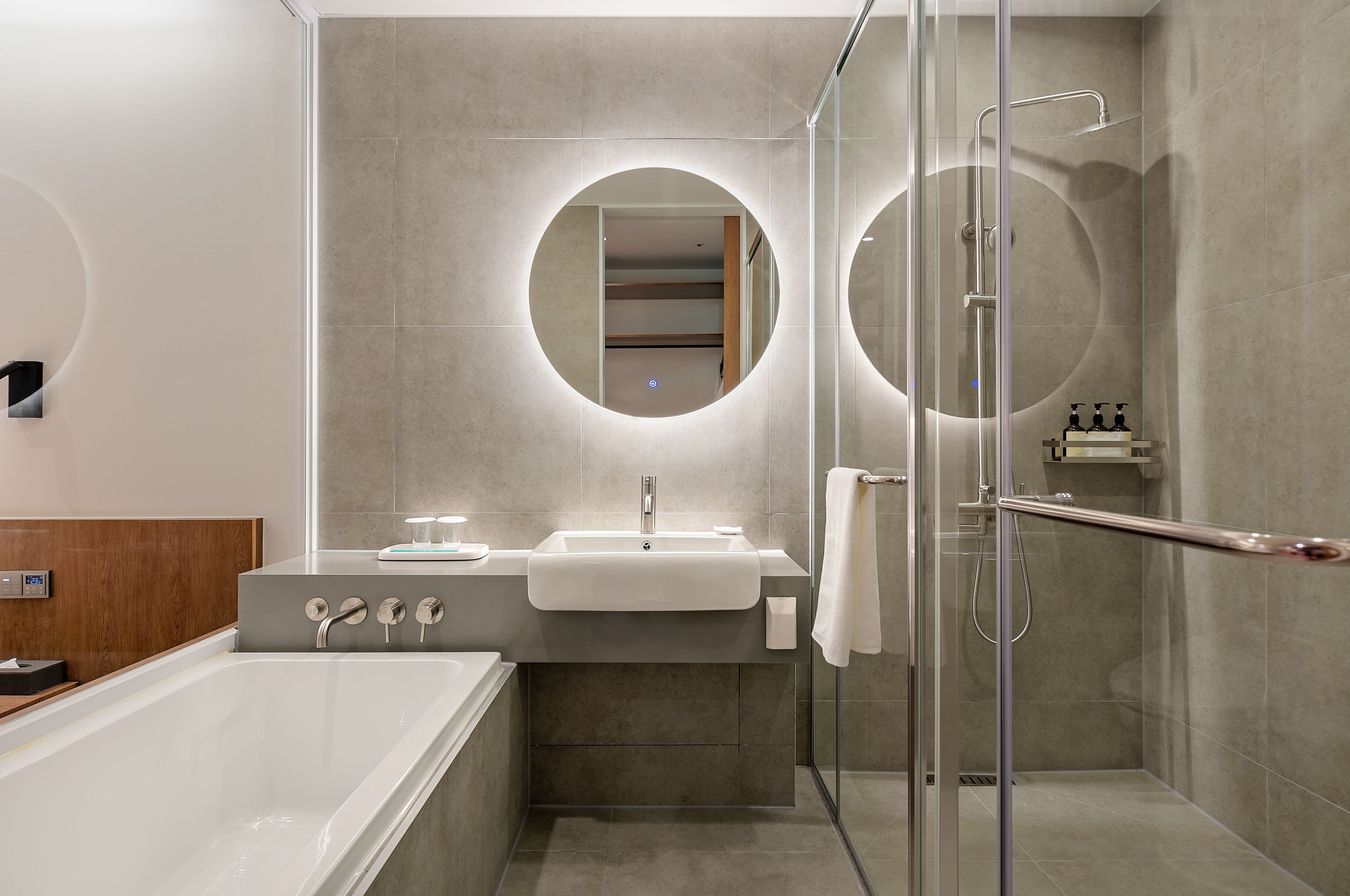 A modern bathroom with a bathtub, a sink, and a glass-enclosed shower area.