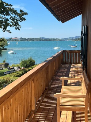 A wooden deck with a view of a lake and sailboats. - Suite with a balcony offering a magnificent view of the lake (Frauenchiemsee)
