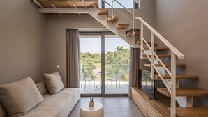 Ein modernes Wohnzimmer mit einer Couch, einem runden Couchtisch und einer Holztreppe.