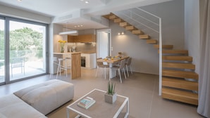 Ein modernes Interieur mit Treppe, Essbereich und Wohnbereich mit Sofa und Couchtisch.
