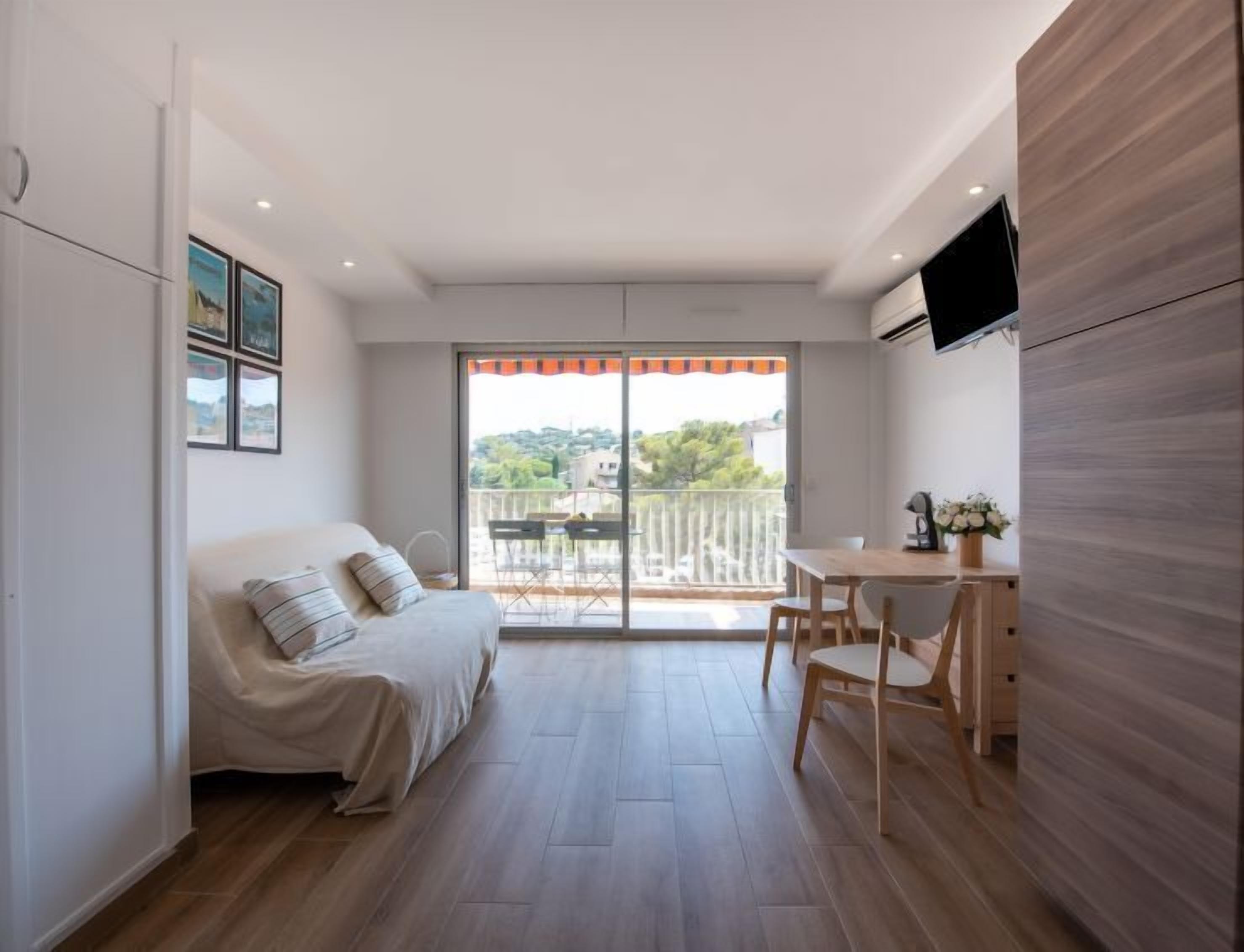 Een moderne slaapkamer met een bed, een bureau en een televisie.