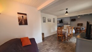 Una sala de estar acogedora con un sofá y un comedor con sillas de madera y una mesa.