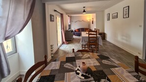 Una sala de estar acogedora con comedor, chimenea y vista al jardín.