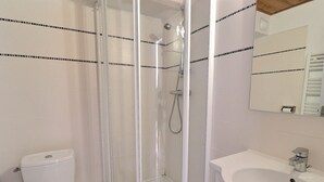 A bathroom with a glass-enclosed shower, a toilet, and a sink. - Comfortable 2-room, ski-in/ski-out, near shops (La Tania)