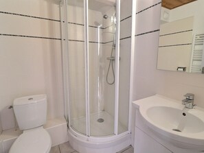 A bathroom with a glass-enclosed shower, a toilet, and a sink. - Comfortable 2-room, ski-in/ski-out, near shops (La Tania)