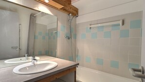 A bathroom with two sinks, a shower, and a bathtub. - Comfortable 2-room, ski-in ski-out, near shops (La Tania)